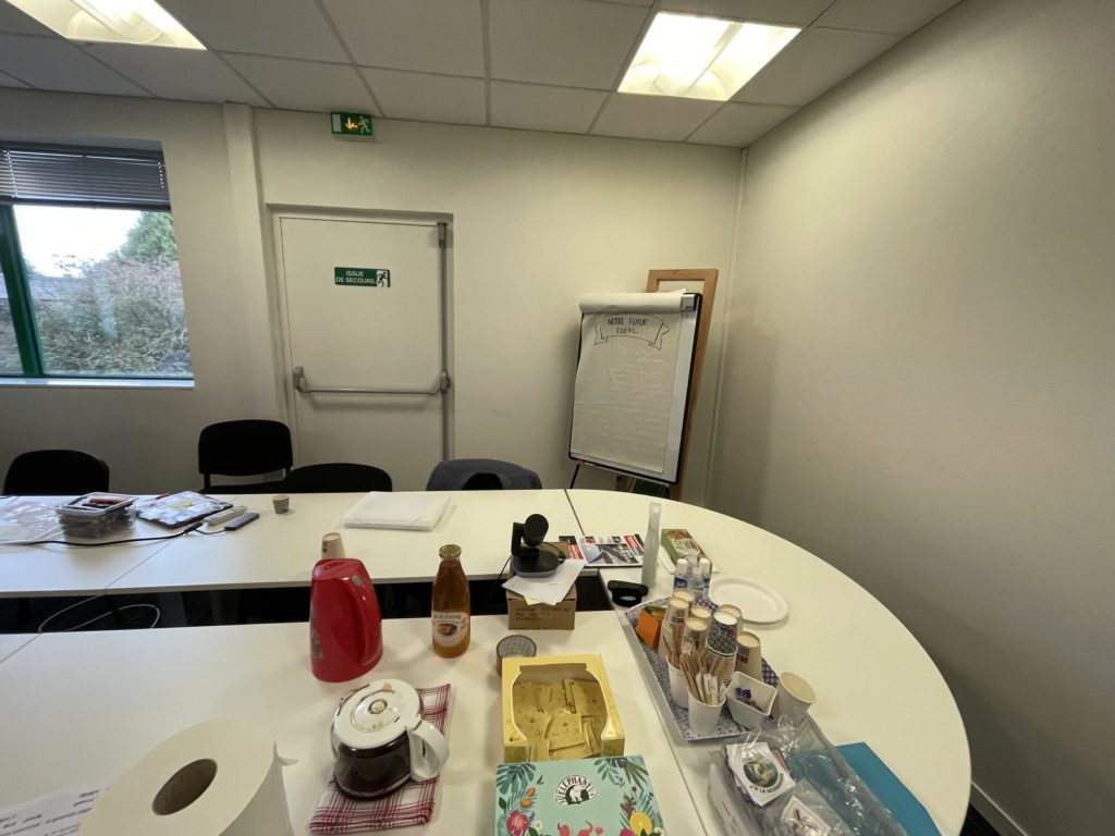 Salle prête avant l'arrivée du groupe : tables en U, café, paperboard, sans personne