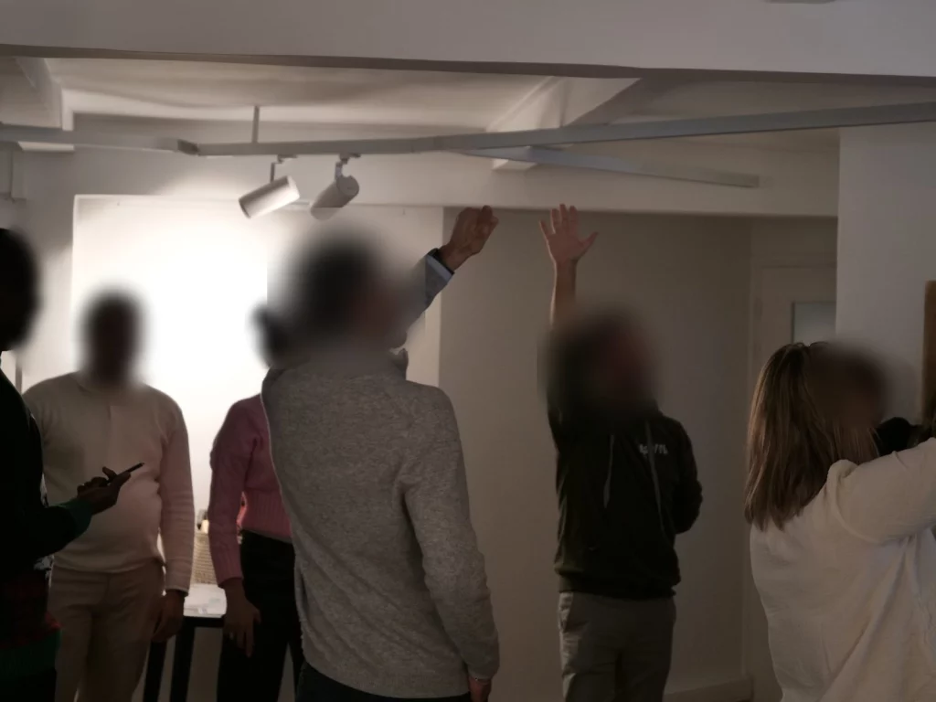 Décision par consentement : mains levées dans un groupe debout, au moment d'un tour rapide